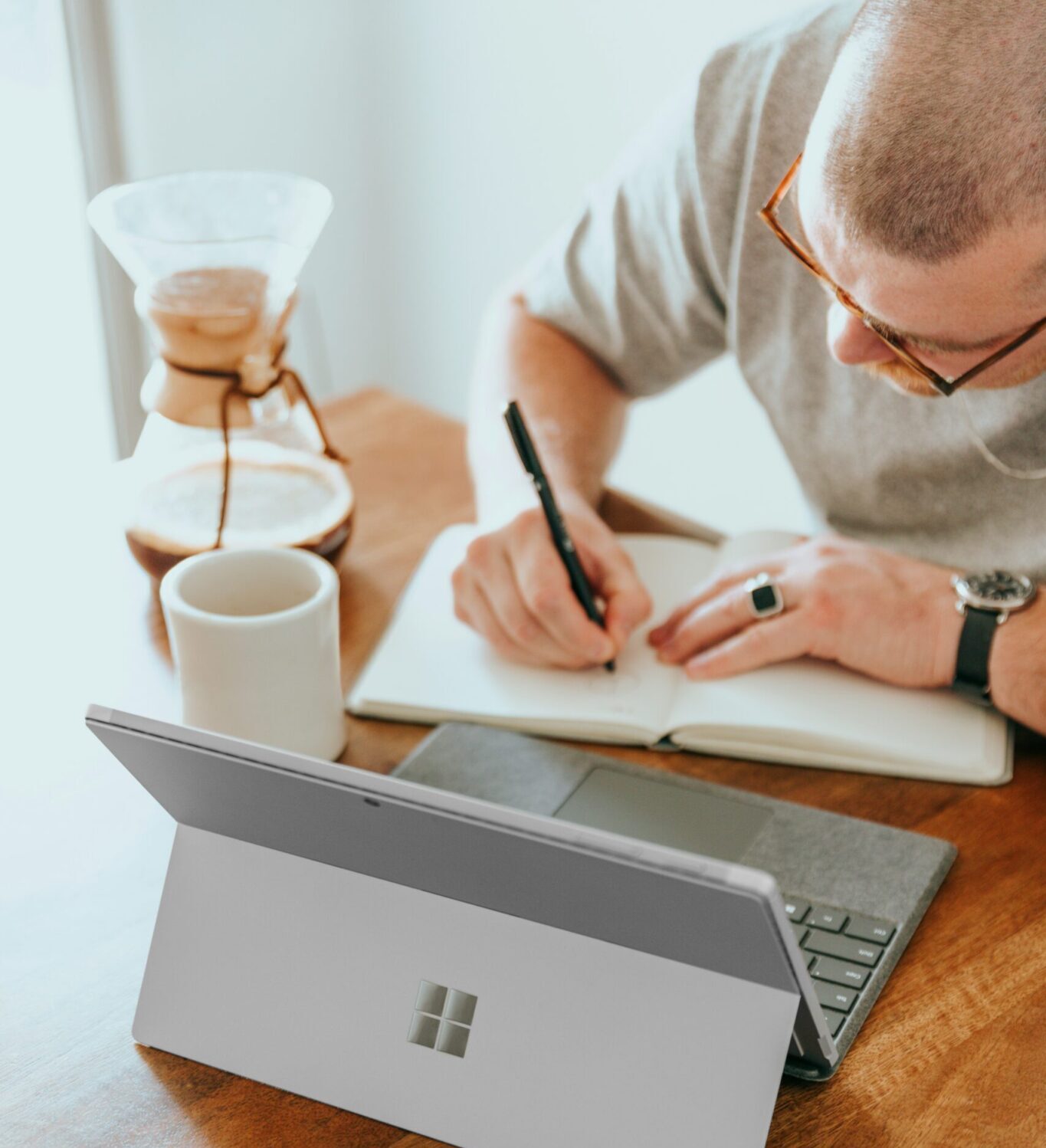 4-Ways-Small-Businesses-Can-Leverage-Microsoft-Copilot-for-SMBs-scaledjpg | ALCON DTS: Austin, TX Best Managed IT Support Services a man sitting at a table writing on a notebook