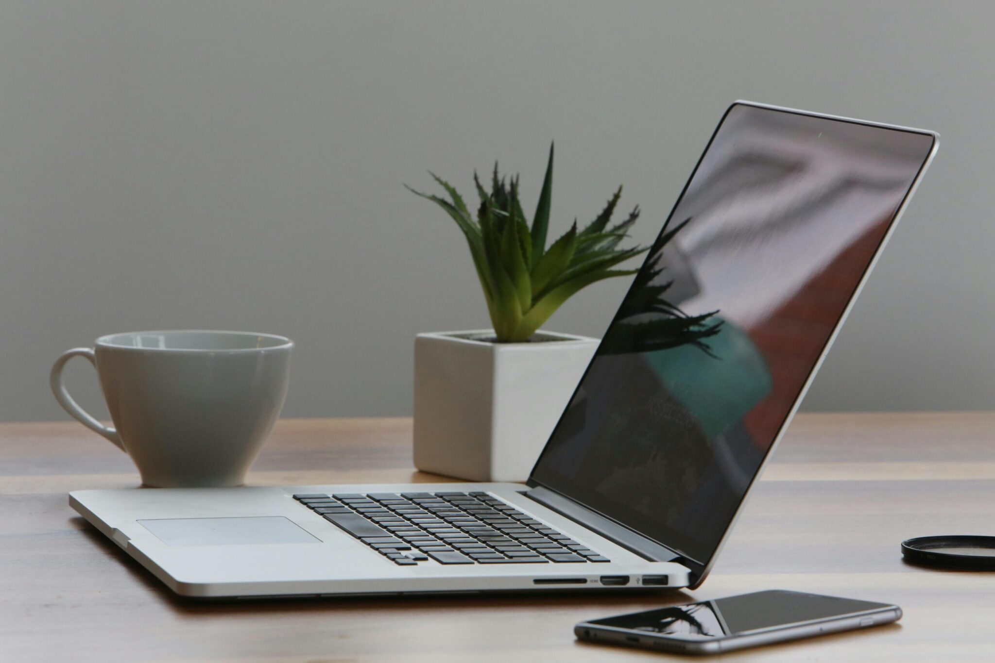 7-Ways-Using-AI-for-Work-Can-Get-Complicated-scaledjpg | ALCON DTS: Austin, TX Best Managed IT Support Services Free Minimalist home office desk with laptop, smartphone, and plant for a modern work environment. Stock Photo