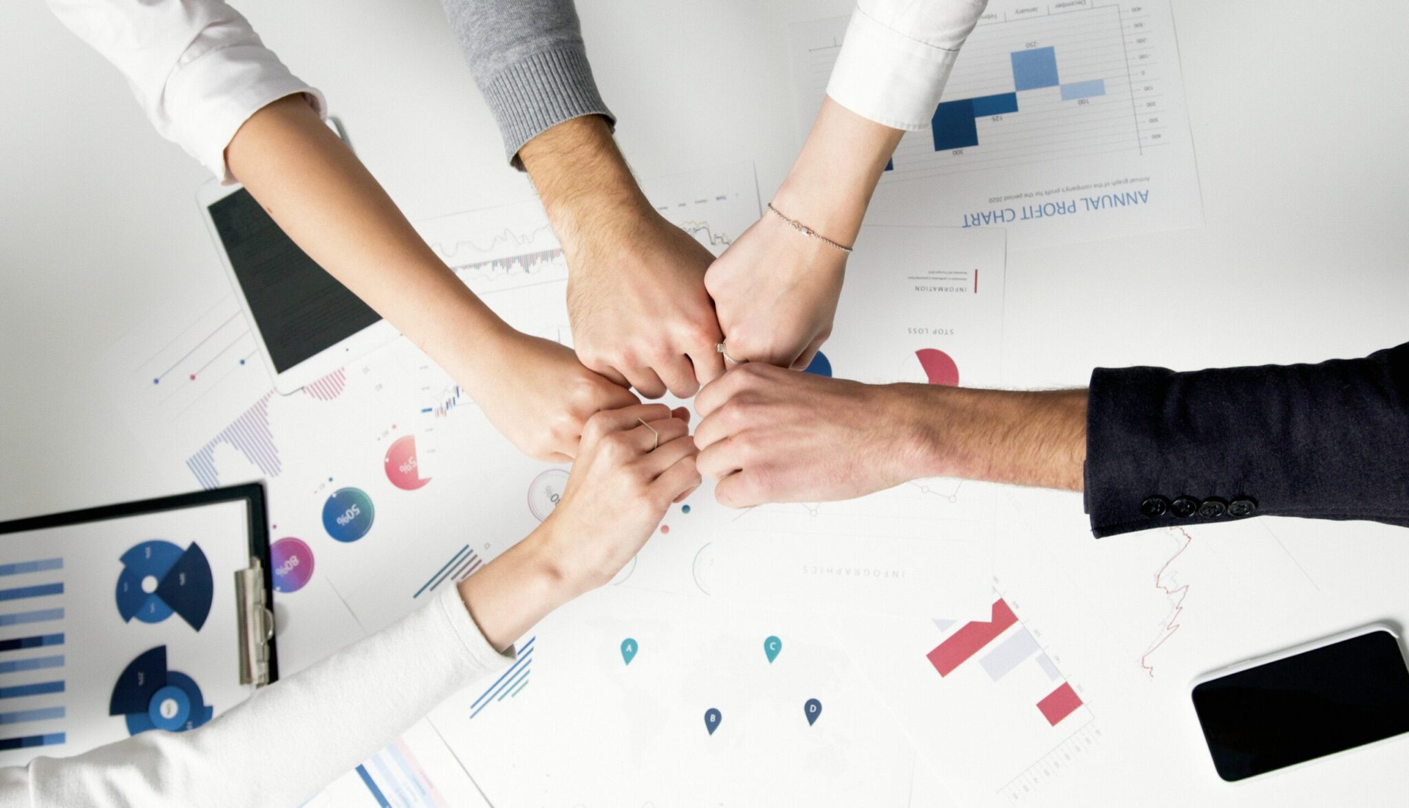 How-Smart-IT-Boosts-Employee-Morale-and-Keeps-Your-Best-People-scaledjpg | ALCON DTS: Austin, TX Best Managed IT Support Services Free Colleagues celebrate success with a fist bump over financial charts depicting teamwork and unity. Stock Photo